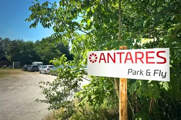 Firmenschild und parkende Autos auf der Outdoorfläche von Antares Park and Fly